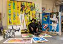 Artist Eugene Ankomah, known for his unique style and social impact projects, pictured with his vibrant works in the studio after winning the BEFFTA Best Visual Artist award