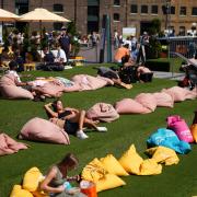 People enjoy the warm weather in Granary Square, London.