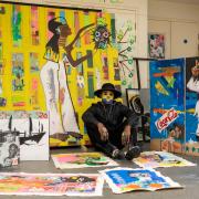 Artist Eugene Ankomah, known for his unique style and social impact projects, pictured with his vibrant works in the studio after winning the BEFFTA Best Visual Artist award