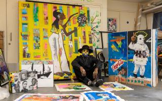 Artist Eugene Ankomah, known for his unique style and social impact projects, pictured with his vibrant works in the studio after winning the BEFFTA Best Visual Artist award